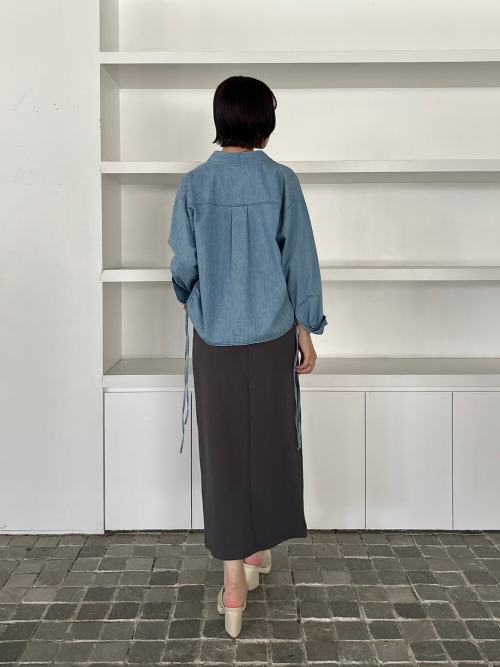 グレー系のワンピース、ホワイト系のサンダル、ブルー系のシャツ/ブラウスを着用したレディースの冬コーディネートの4枚目の写真