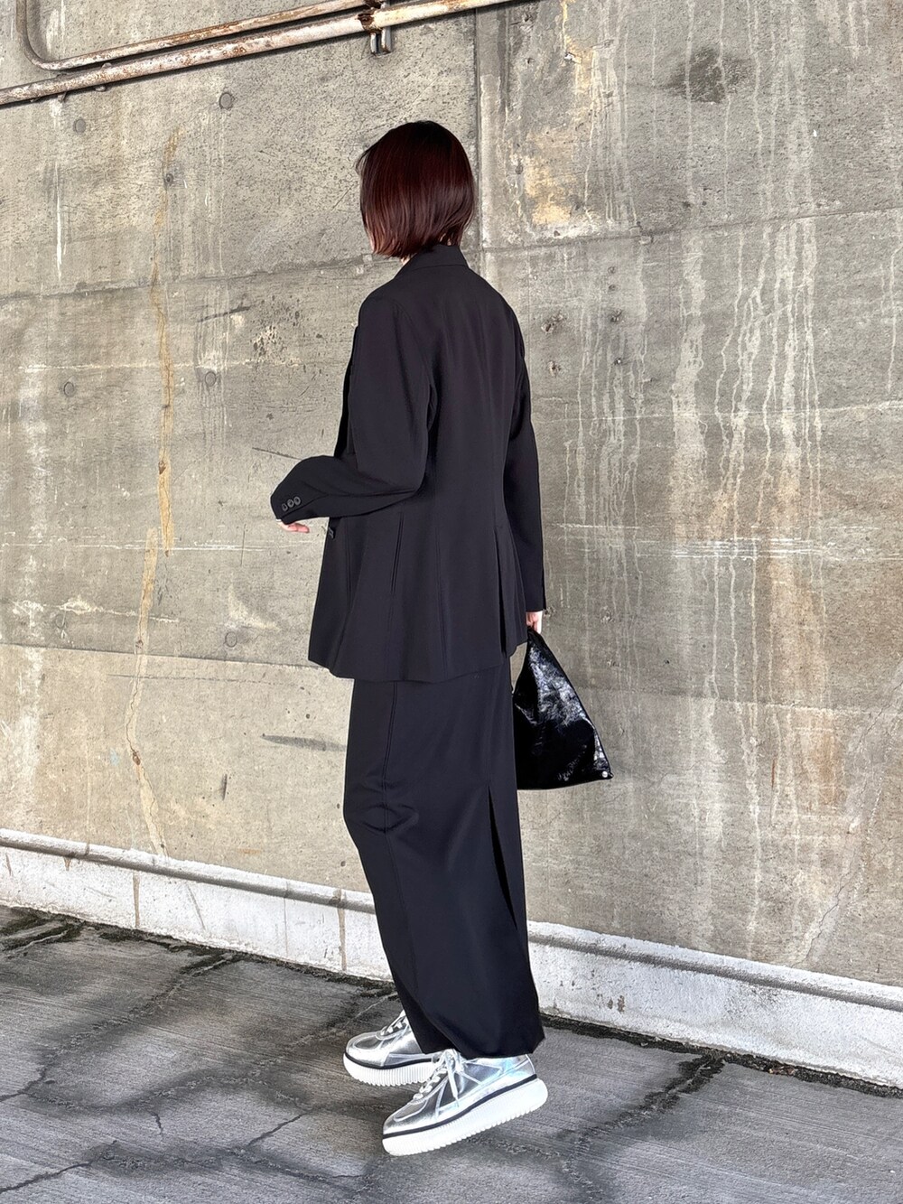 ブラック系のスカート、ブラック系のTシャツ/カットソー、ブラック系のテーラードジャケットを着用したレディースの冬コーディネートの2枚目の写真