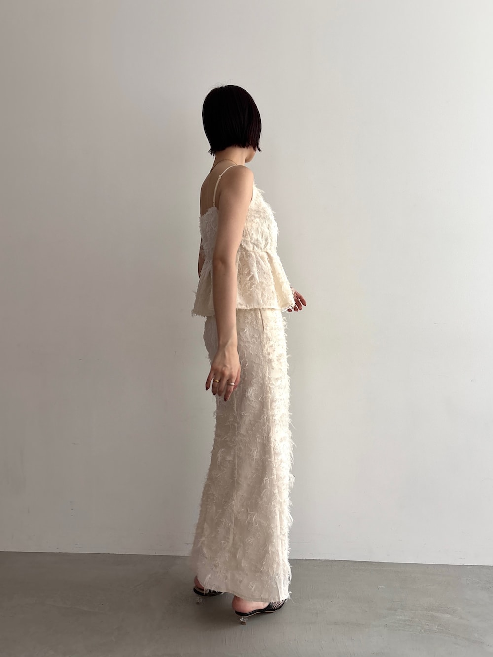 ホワイト系のキャミソール、ホワイト系のスカートを着用したレディースの夏コーディネートの3枚目の写真