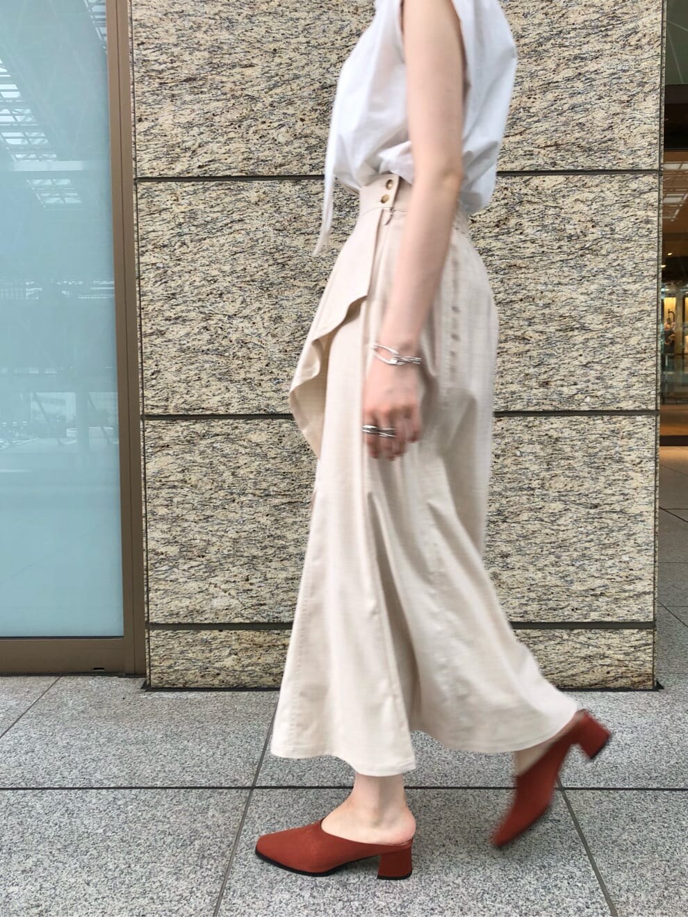 ホワイト系のシャツ/ブラウス、ホワイト系のスカート、オレンジ系のスリッポンを着用したレディースの夏コーディネートの4枚目の写真