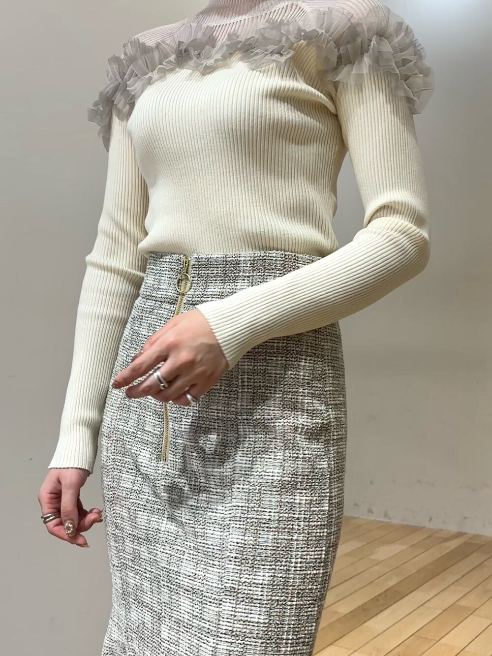 ブラック系のブーツ、ホワイト系のニット/セーター、ホワイト系のスカートを着用したレディースの冬コーディネートの5枚目の写真