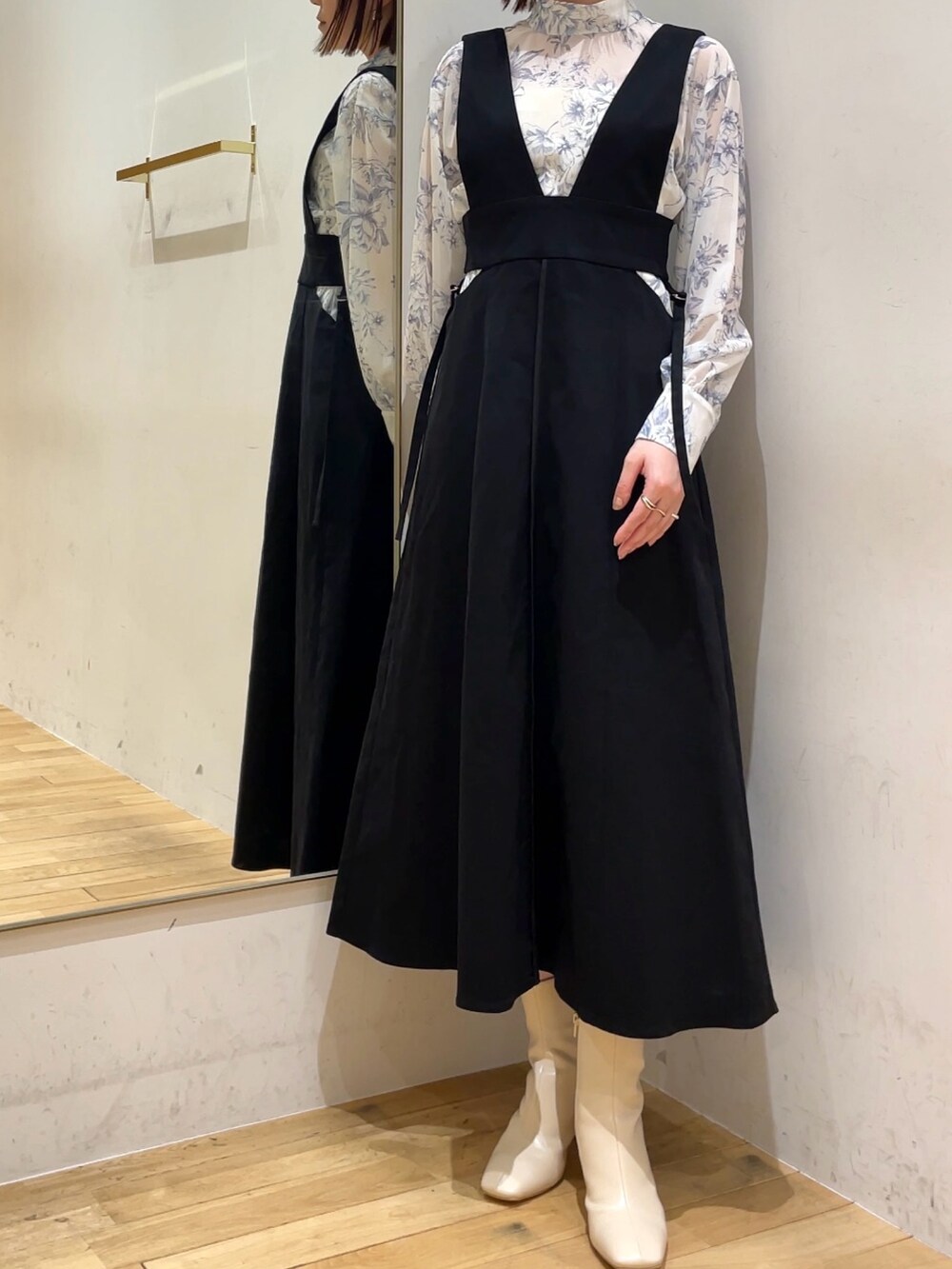 ホワイト系のブーツ、ブルー系のシャツ/ブラウス、ブラック系のジャンパースカートを着用したレディースの冬コーディネートの3枚目の写真