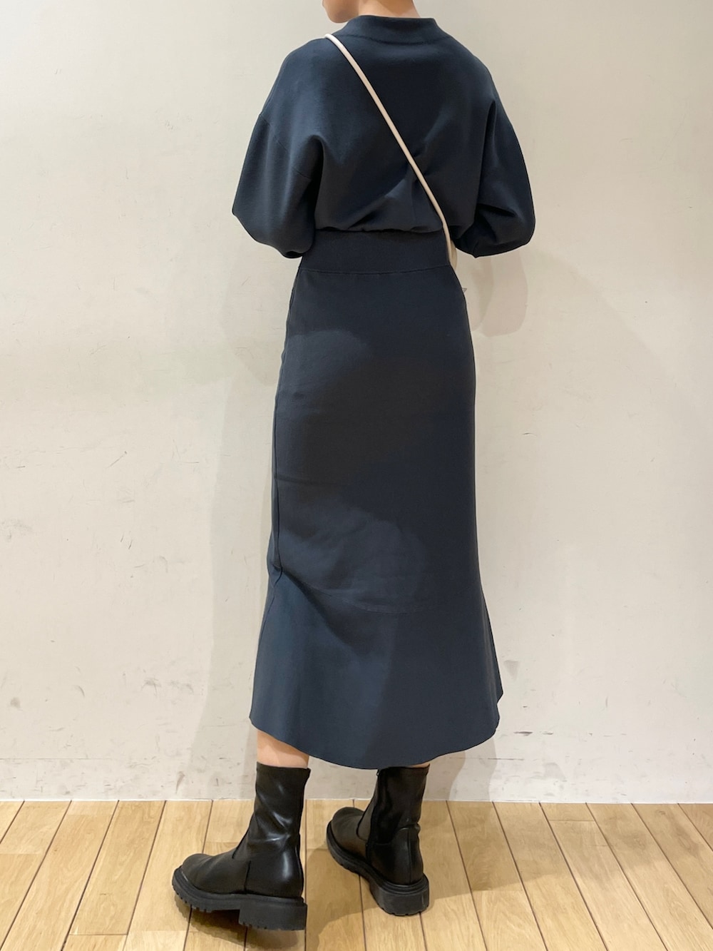 グリーン系のスカート、グリーン系のニット/セーター、ブラック系のブーツを着用したレディースの冬コーディネートの5枚目の写真