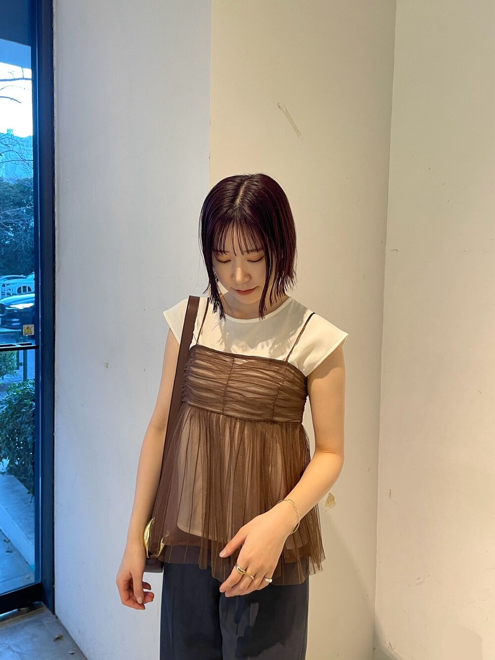 ブラウン系のTシャツ/カットソー、ブルー系のスラックス、ブラック系のサンダルを着用したレディースの春コーディネートの5枚目の写真