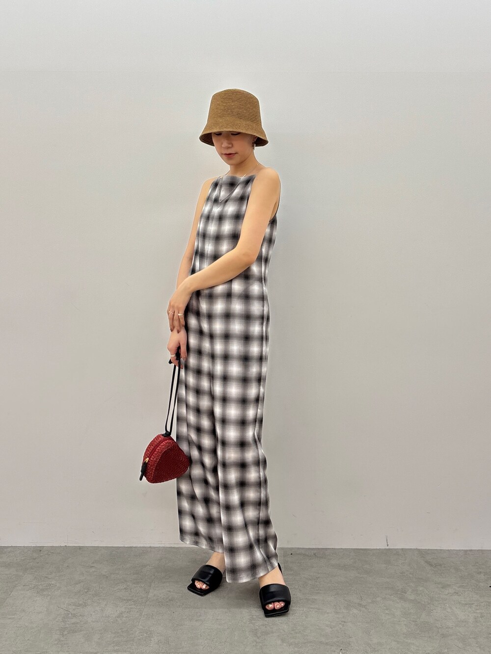 ブラック系のつなぎ/オールインワン、レッド系のショルダーバッグ、ブラック系のサンダルを着用したレディースの春コーディネートの2枚目の写真