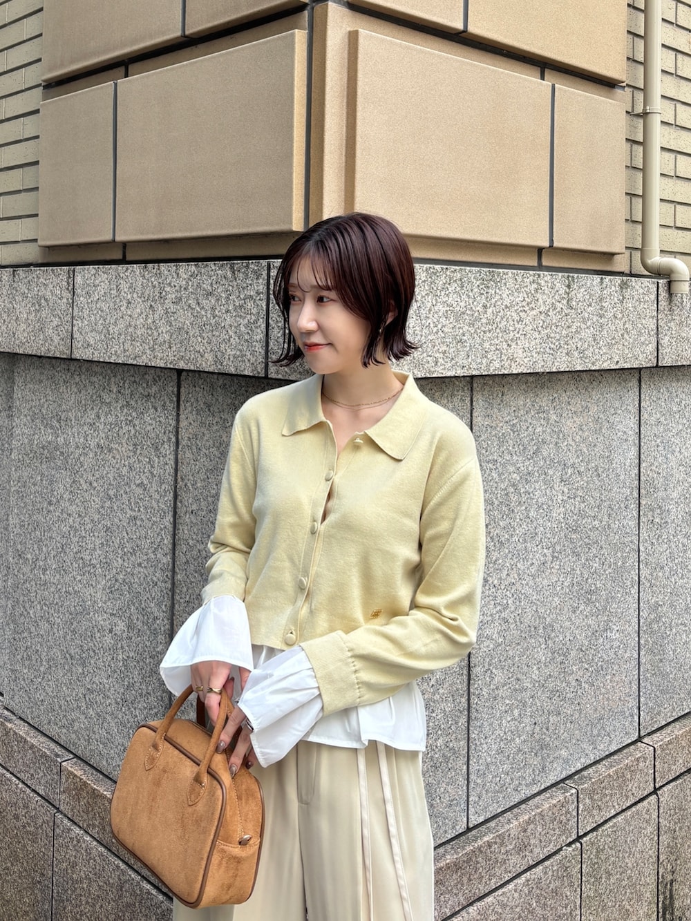 ベージュ系のその他パンツ、イエロー系のハンドバッグ、イエロー系のカーディガン/ボレロを着用したレディースの秋コーディネートの3枚目の写真