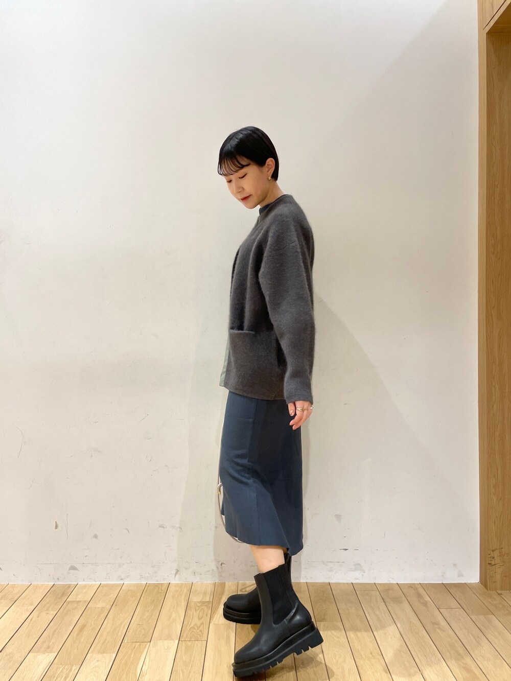 グレー系のカーディガン/ボレロ、グリーン系のニット/セーター、グリーン系のスカートを着用したレディースの冬コーディネートの3枚目の写真