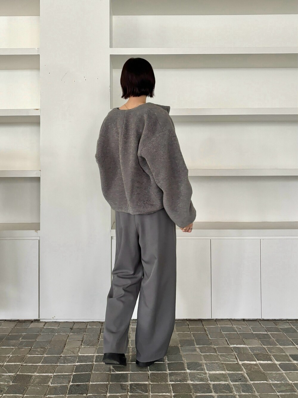 グレー系のブルゾン、グレー系のその他パンツ、ブラック系のブーツを着用したレディースの秋コーディネートの3枚目の写真