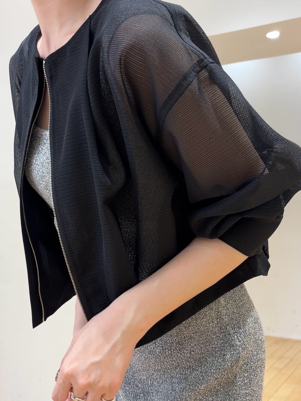 グレー系のワンピース、ブラック系のブルゾン、ブラック系のハンドバッグを着用したレディースの春コーディネートの5枚目の写真