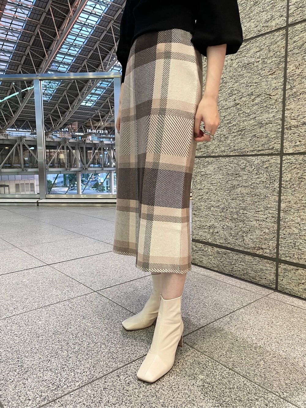 ホワイト系のその他シューズ、ブラック系のニット/セーター、ベージュ系のノーカラーコートを着用したレディースの冬コーディネートの5枚目の写真