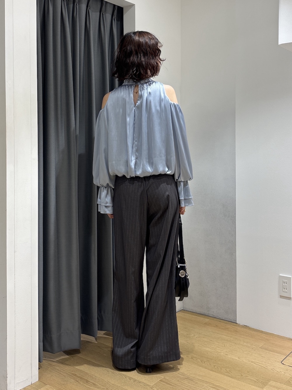 ブルー系のシャツ/ブラウス、グレー系のその他パンツ、ブラック系のハンドバッグを着用したレディースの秋コーディネートの4枚目の写真