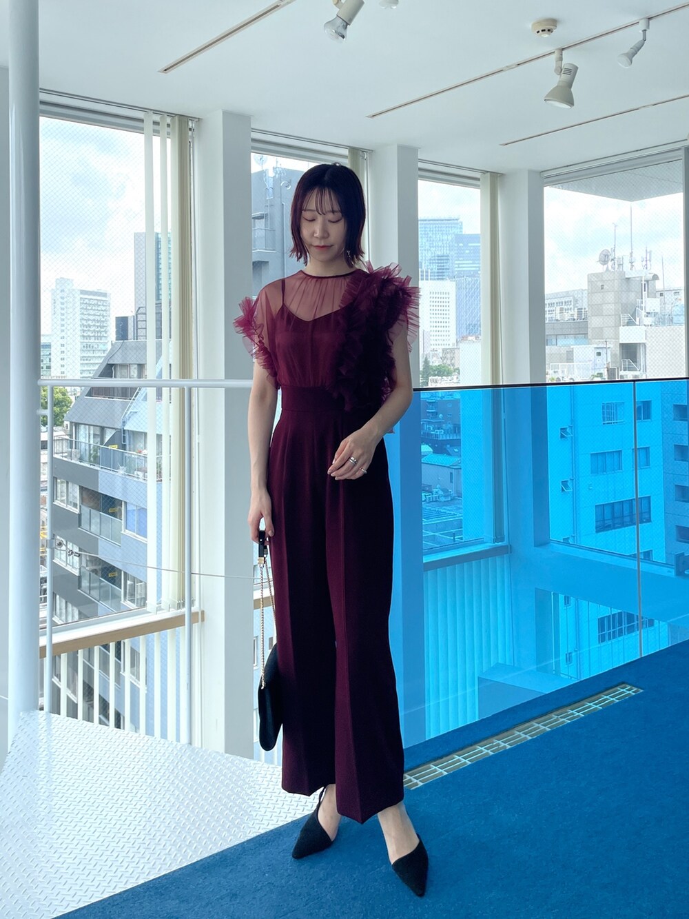 レッド系のパンツドレスを着用したレディースの春コーディネートの5枚目の写真