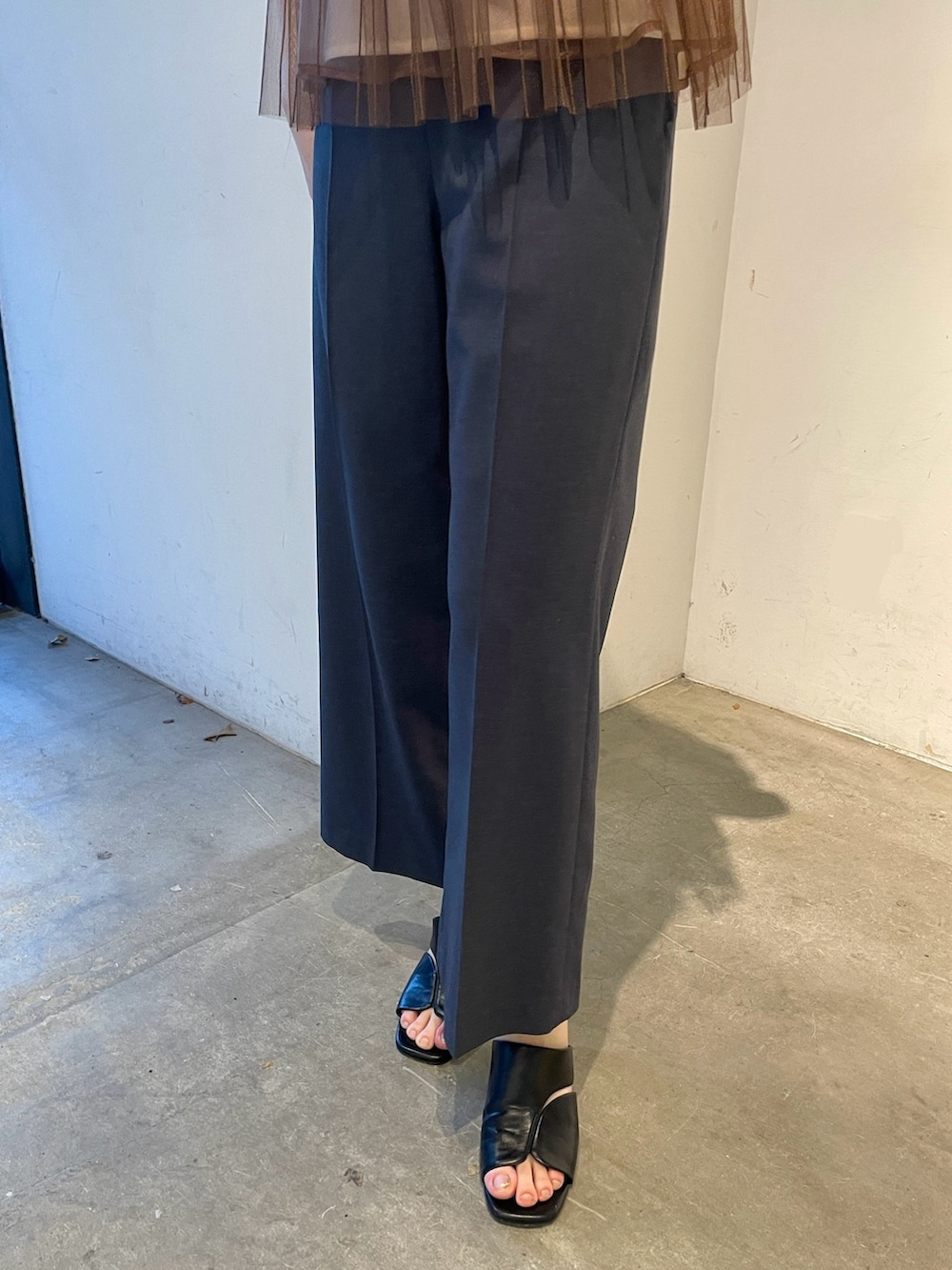 ブラウン系のTシャツ/カットソー、ブルー系のスラックス、ブラック系のサンダルを着用したレディースの春コーディネートの8枚目の写真