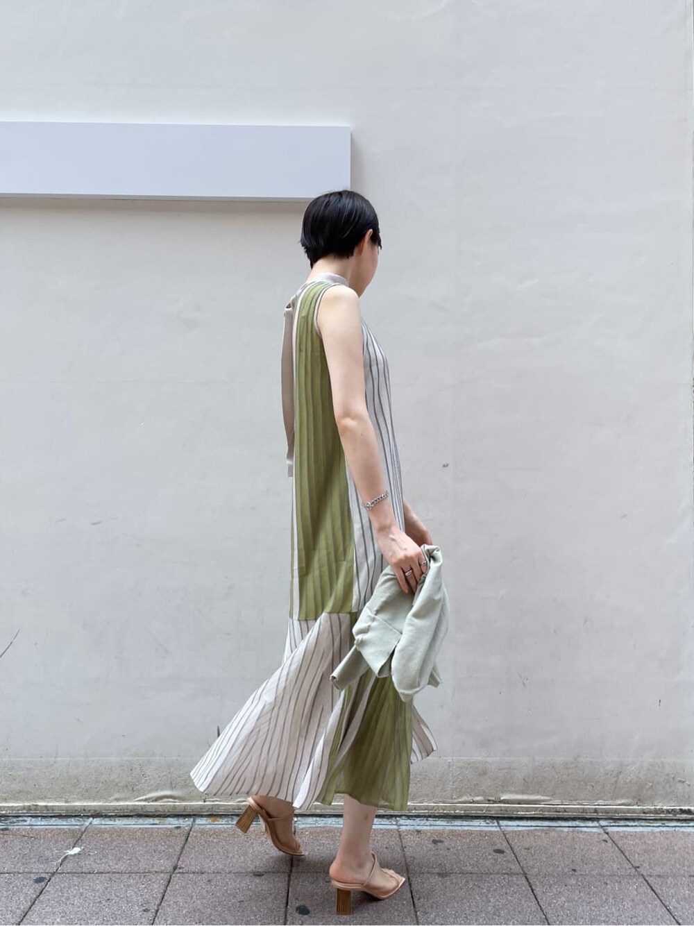 グリーン系のワンピース、グリーン系のカーディガン/ボレロ、ベージュ系のサンダルを着用したレディースの夏コーディネートの3枚目の写真