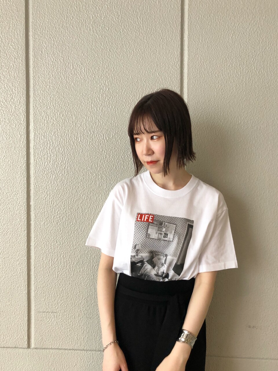 ブラック系のスカート、ブラック系のその他シューズ、ホワイト系のTシャツ/カットソーを着用したレディースの夏コーディネートの2枚目の写真