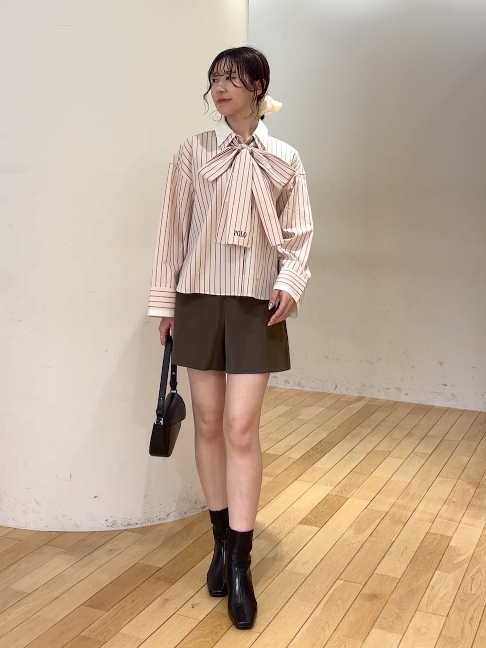 ブラウン系のその他パンツ、ブラック系のブーツ、ブラック系のハンドバッグを着用したレディースの夏コーディネートの2枚目の写真