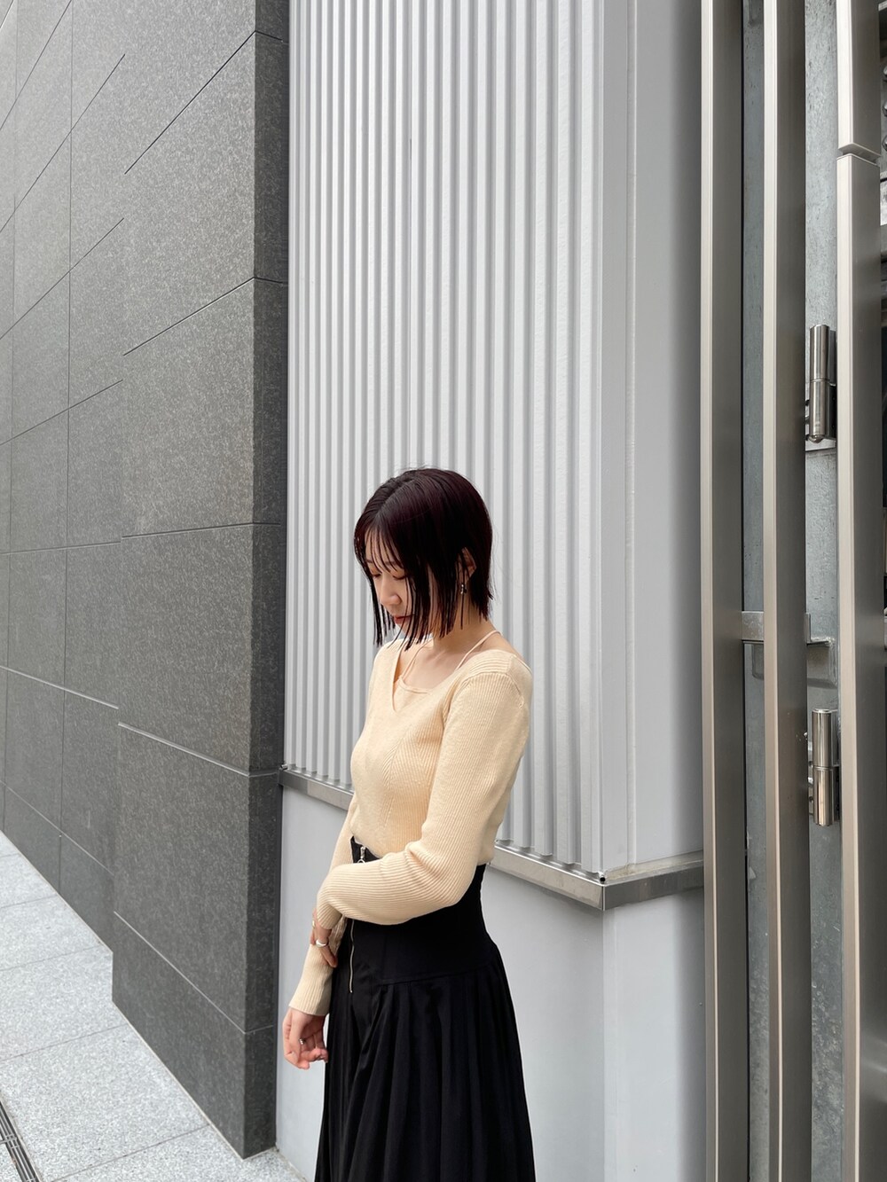 ブラック系のブーツ、ホワイト系のニット/セーター、ブラック系のスカートを着用したレディースの冬コーディネートの6枚目の写真