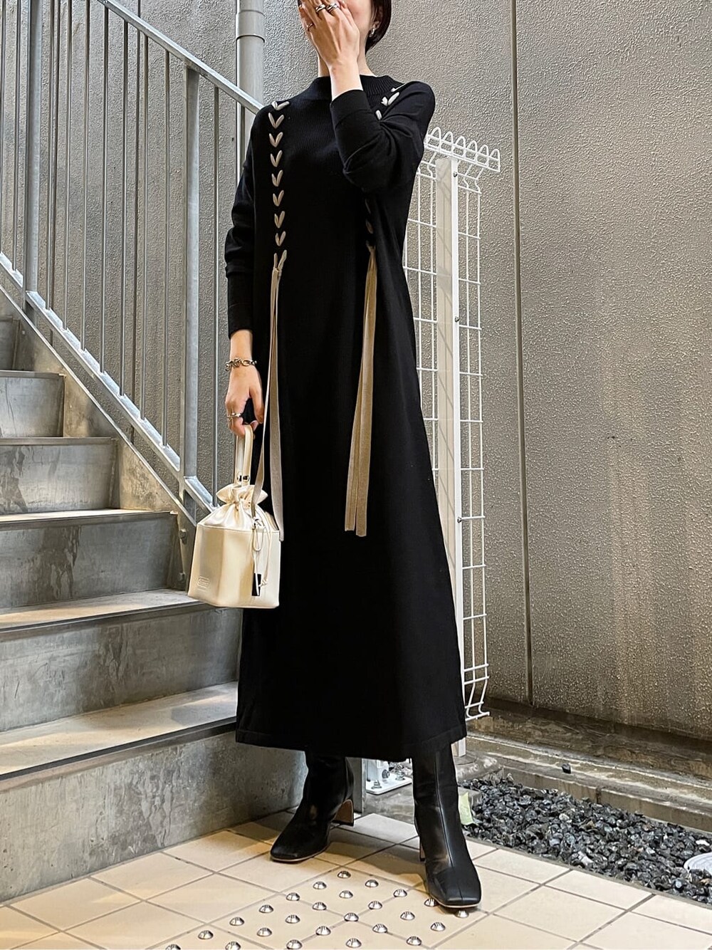 ブラック系のその他シューズ、ホワイト系のハンドバッグ、ブラック系のワンピースを着用したレディースの冬コーディネートの2枚目の写真