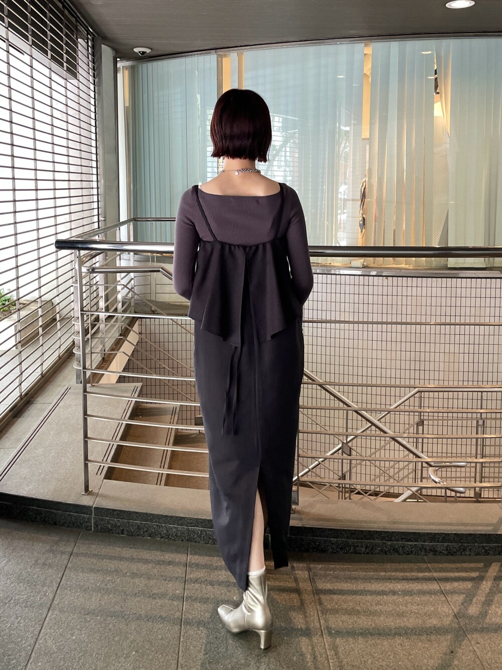 グレー系のニット/セーター、シルバー系のブーツ、ブラック系のワンピースを着用したレディースの秋コーディネートの4枚目の写真