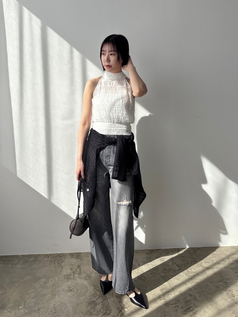 グレー系のデニムパンツ、ブラック系のパンプス、ブラック系のテーラードジャケットを着用したレディースの春コーディネートの2枚目の写真
