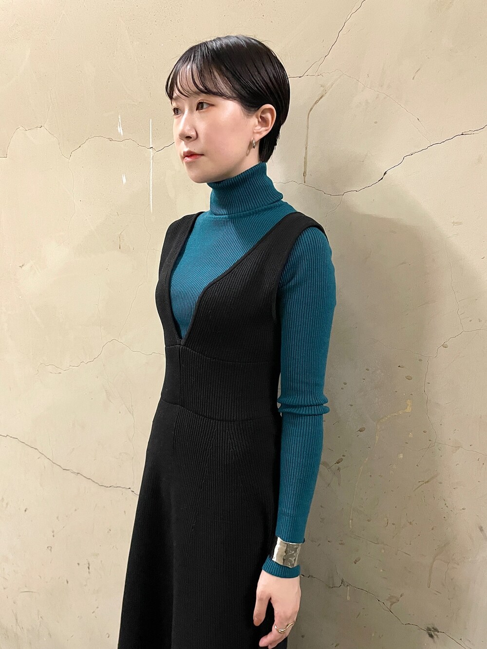 ブラック系のスカート、グリーン系のニット/セーター、ブラック系のブーツを着用したレディースの秋コーディネートの6枚目の写真