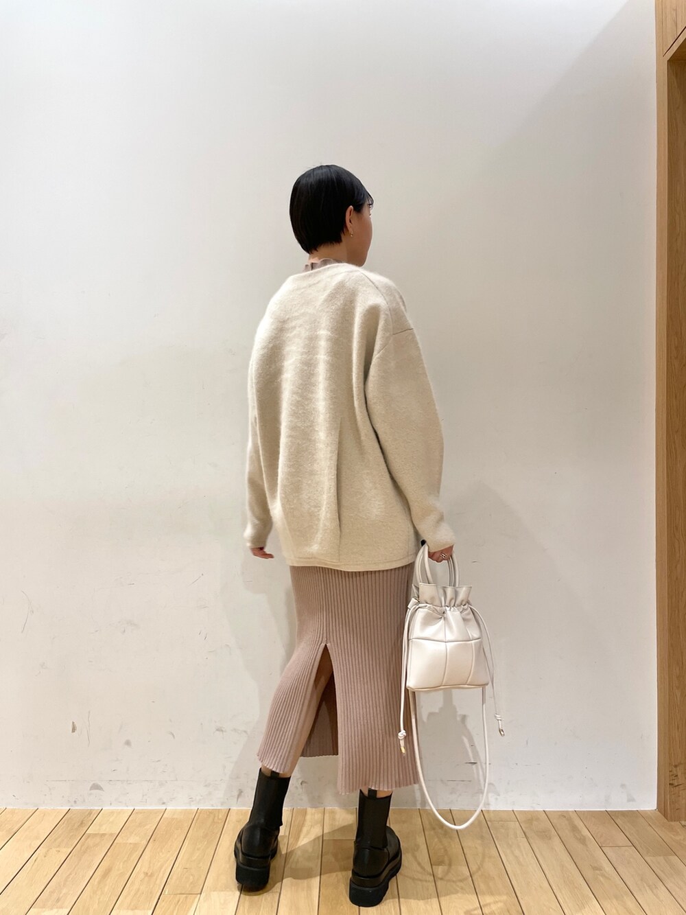 ホワイト系のカーディガン/ボレロ、ベージュ系のワンピース、ホワイト系のハンドバッグを着用したレディースの冬コーディネートの3枚目の写真