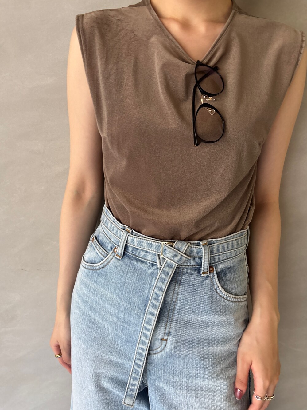 ブルー系のデニムパンツ、ブラック系のサンダル、ブラウン系のTシャツ/カットソーを着用したレディースの夏コーディネートの4枚目の写真