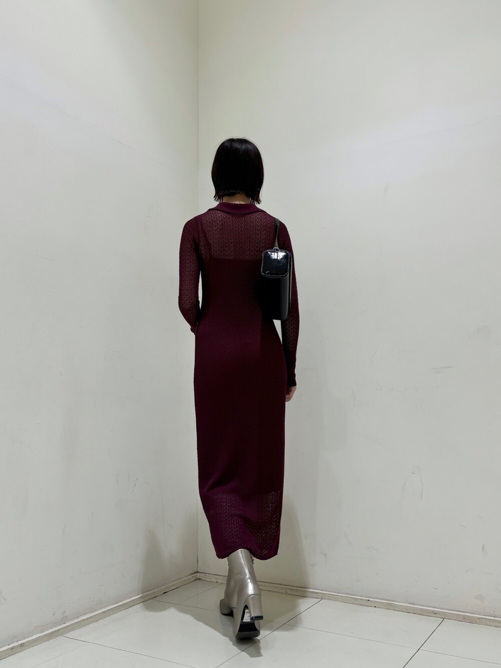 パープル系のワンピース、ブラック系のショルダーバッグ、シルバー系のブーツを着用したレディースの秋コーディネートの4枚目の写真