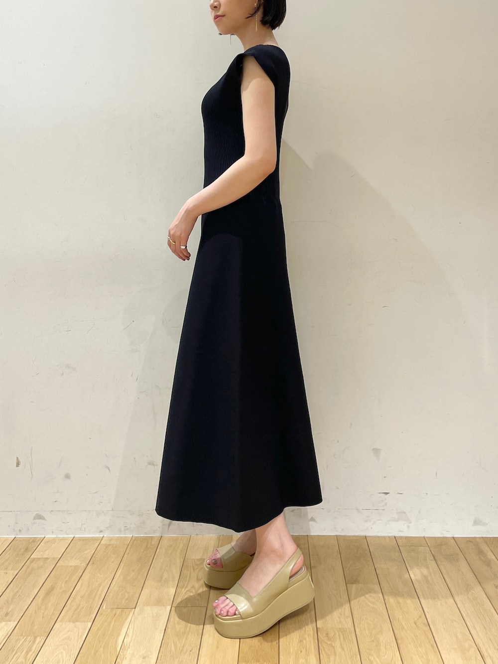 ブラック系のワンピース、ブラウン系のハンドバッグ、ベージュ系のサンダルを着用したレディースの夏コーディネートの7枚目の写真