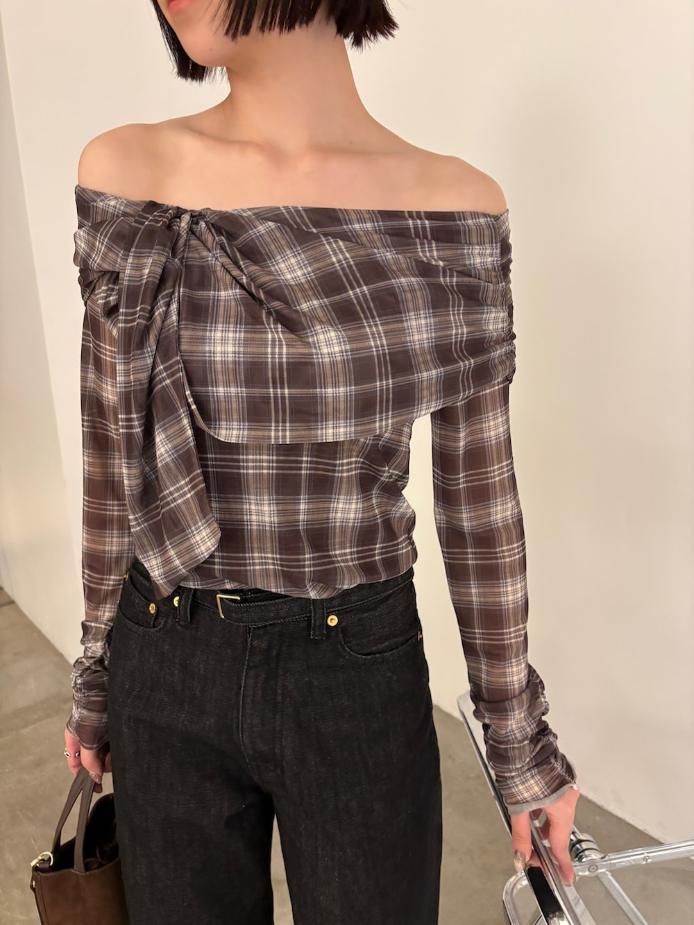 ブラウン系のシャツ/ブラウス、ブラウン系のハンドバッグ、ブラック系のデニムパンツを着用したレディースの春コーディネートの3枚目の写真