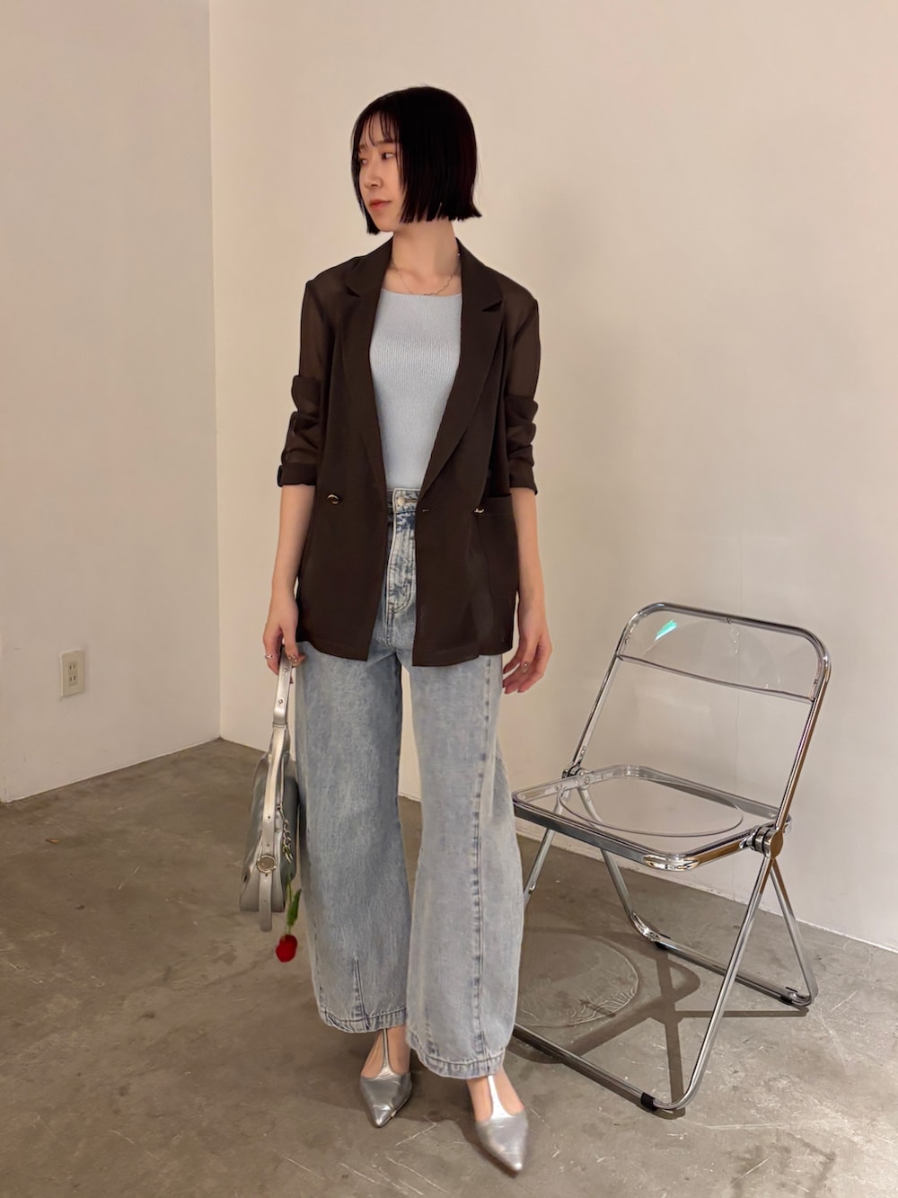 ブルー系のデニムパンツ、ブラウン系のテーラードジャケット、ブルー系のタンクトップを着用したレディースの春コーディネートの2枚目の写真