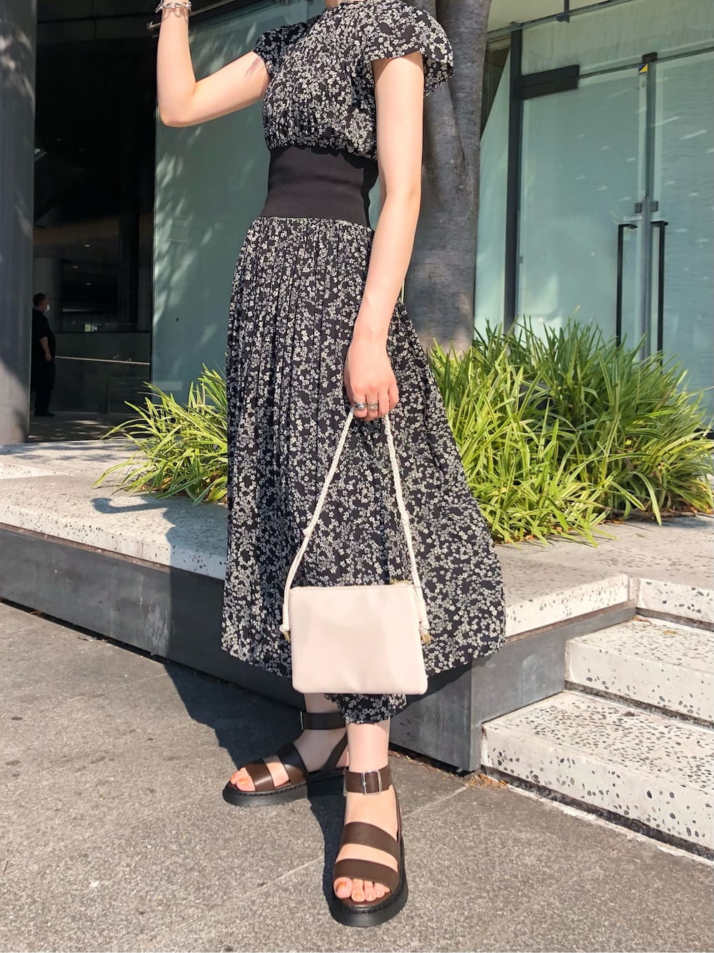 ホワイト系のショルダーバッグ、ブラック系のワンピース、ブラウン系のサンダルを着用したレディースの夏コーディネートの6枚目の写真