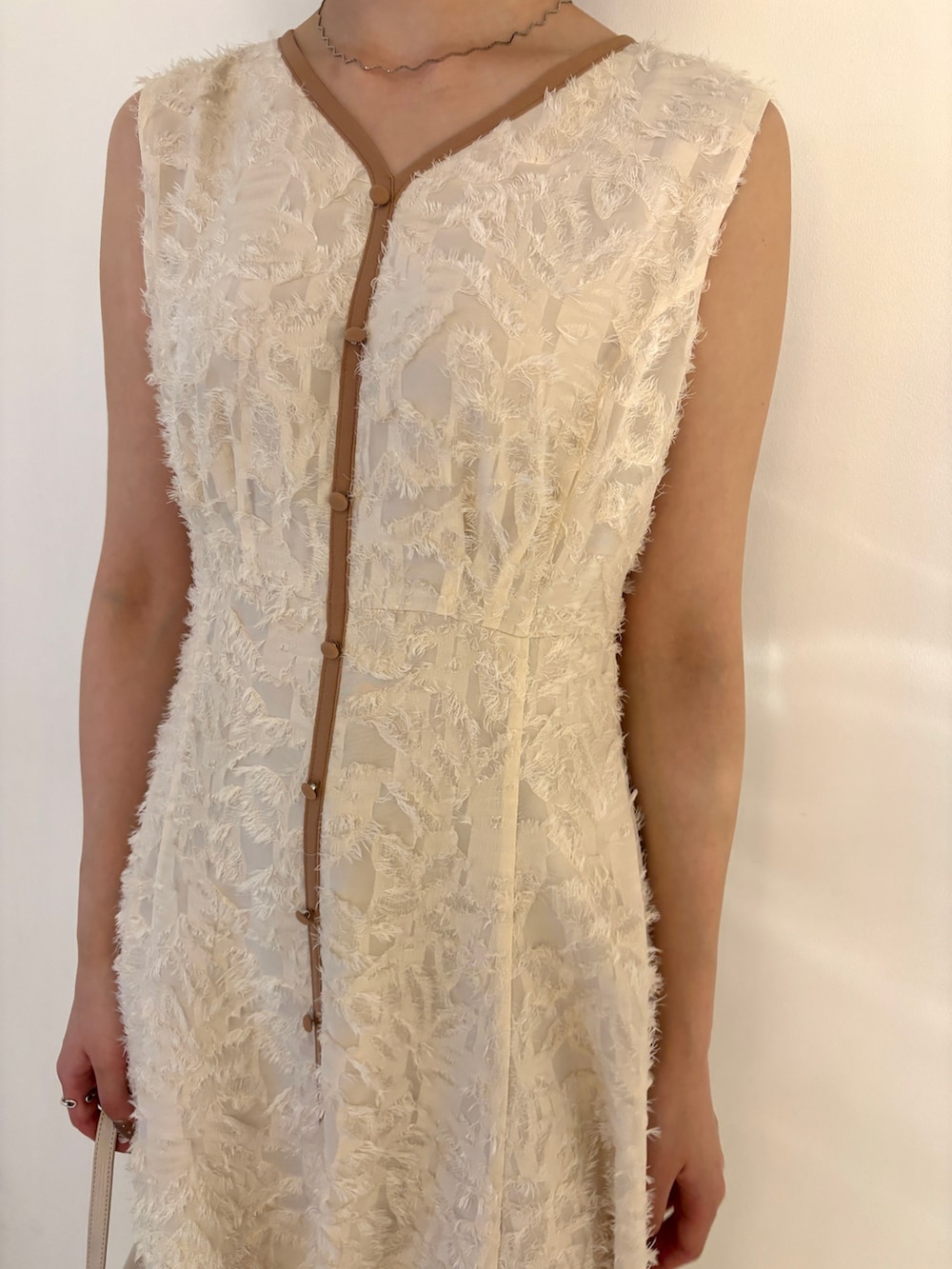 ホワイト系のワンピース、グリーン系のパンプスを着用したレディースの春コーディネートの3枚目の写真