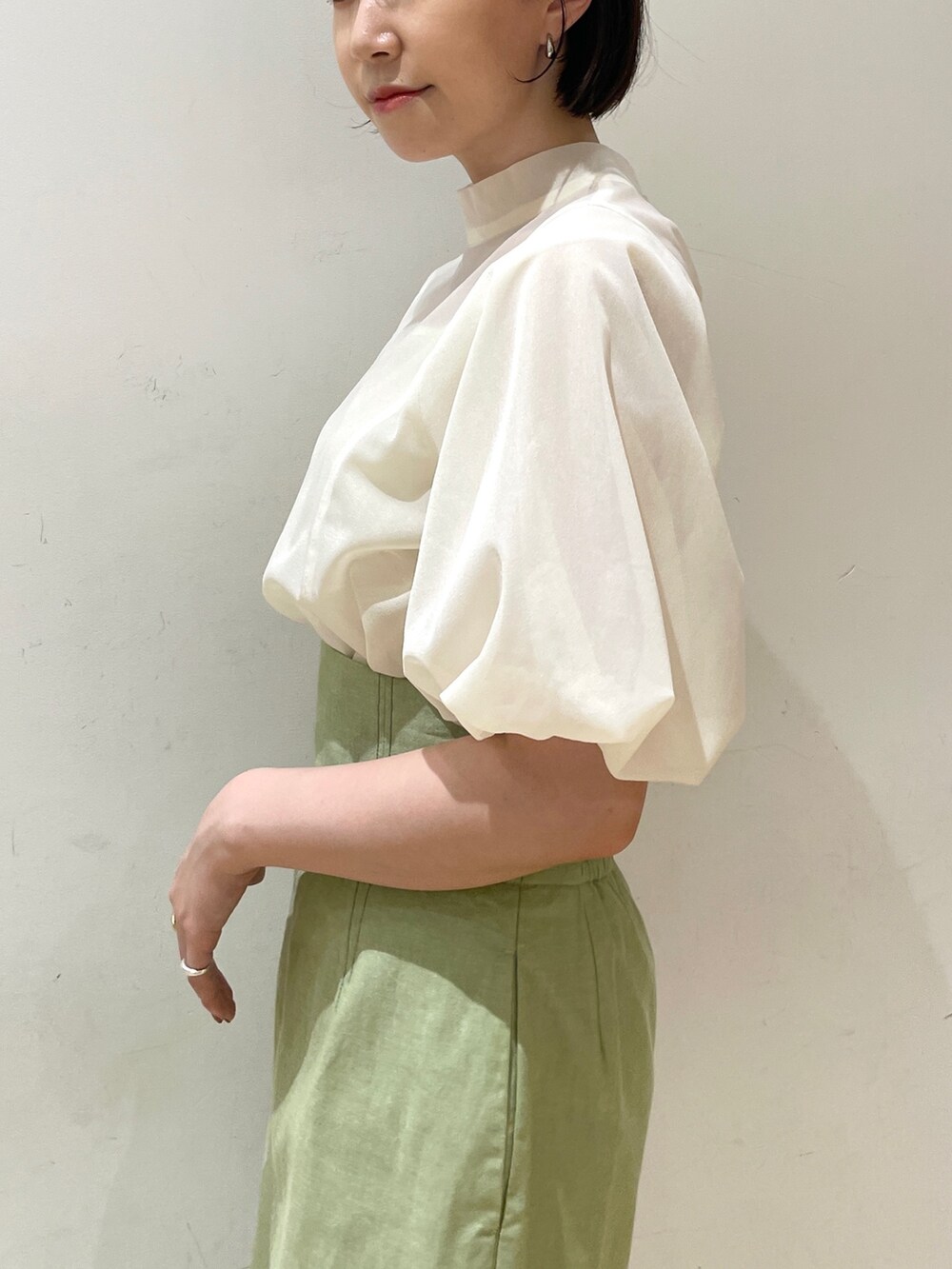 ベージュ系のサンダル、グリーン系のスカート、ホワイト系のシャツ/ブラウスを着用したレディースの夏コーディネートの7枚目の写真