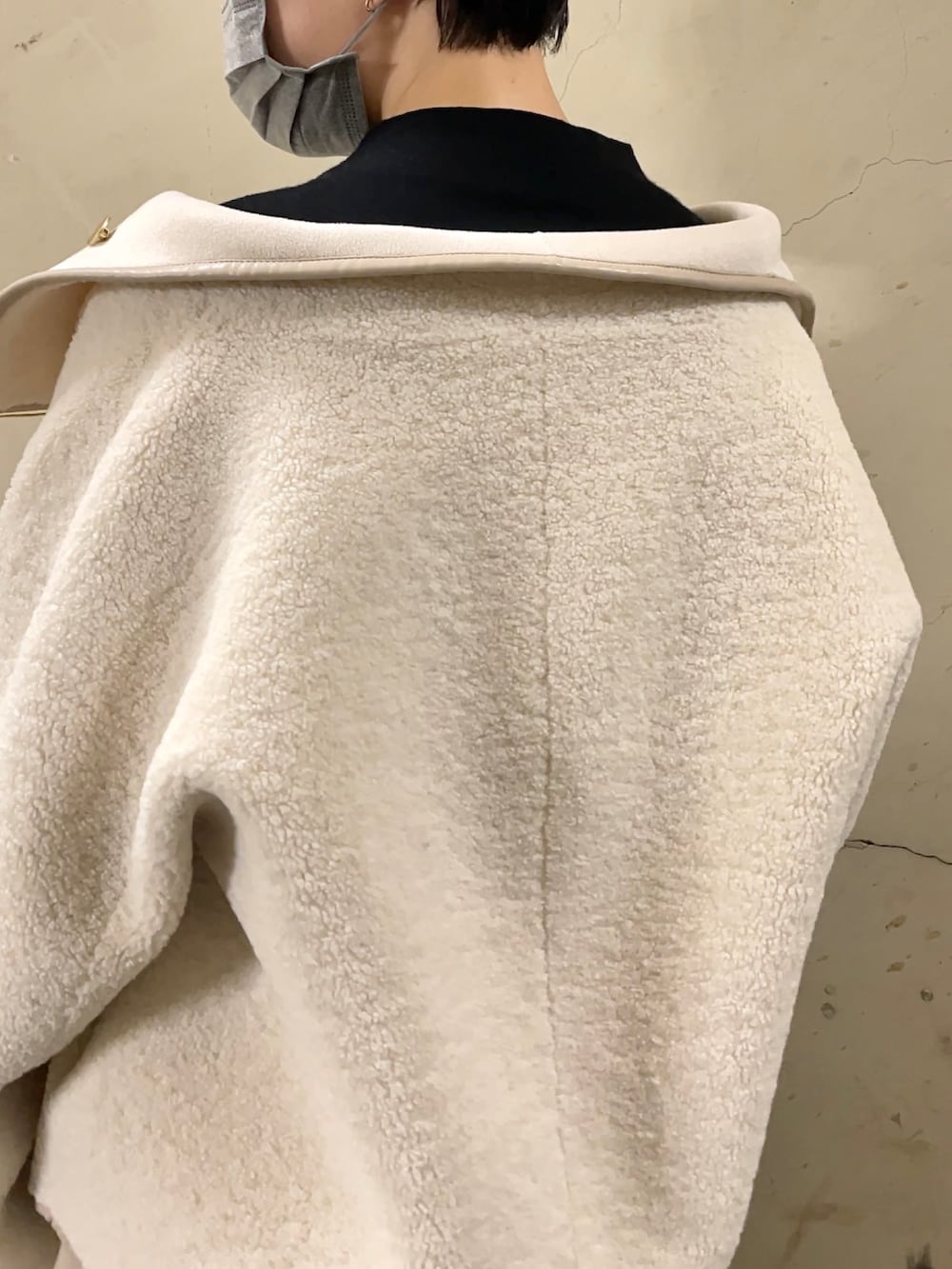 ホワイト系のブルゾン、ブラック系のブーツ、ベージュ系のスカートを着用したレディースの秋コーディネートの6枚目の写真