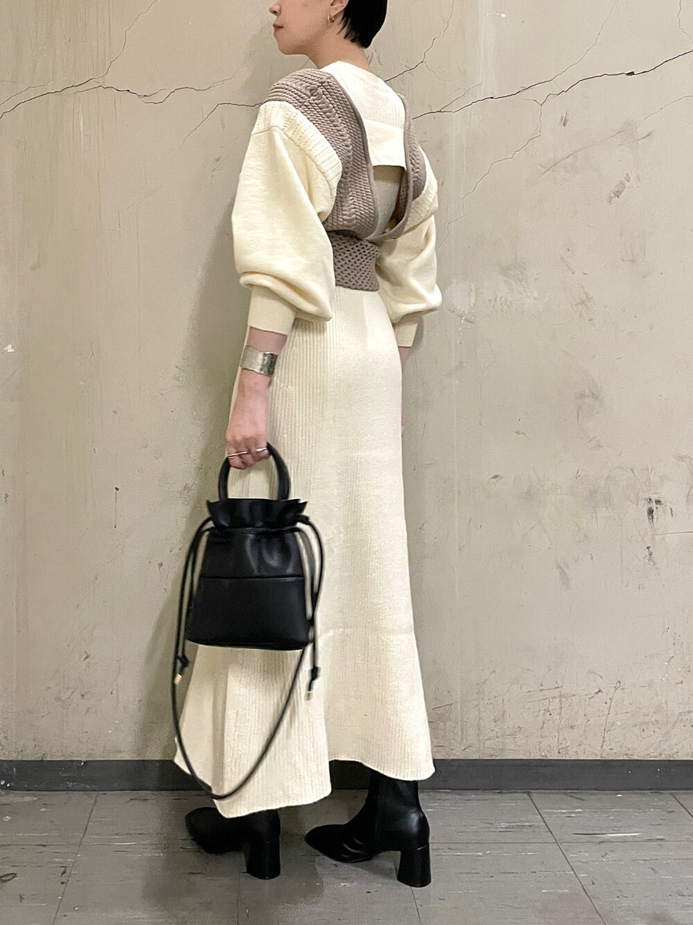 ホワイト系のワンピース、ブラック系のブーツ、ブラック系のハンドバッグを着用したレディースの秋コーディネートの5枚目の写真