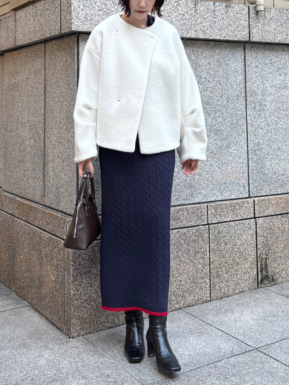 ホワイト系のブルゾン、ブルー系のワンピース、ブラウン系のボストンバッグを着用したレディースの秋コーディネートの2枚目の写真
