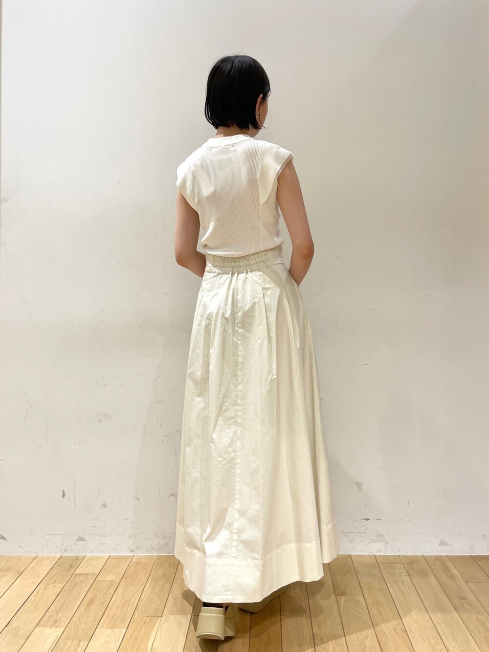 ホワイト系のニット/セーター、ホワイト系のスカート、ホワイト系のハンドバッグを着用したレディースの夏コーディネートの4枚目の写真