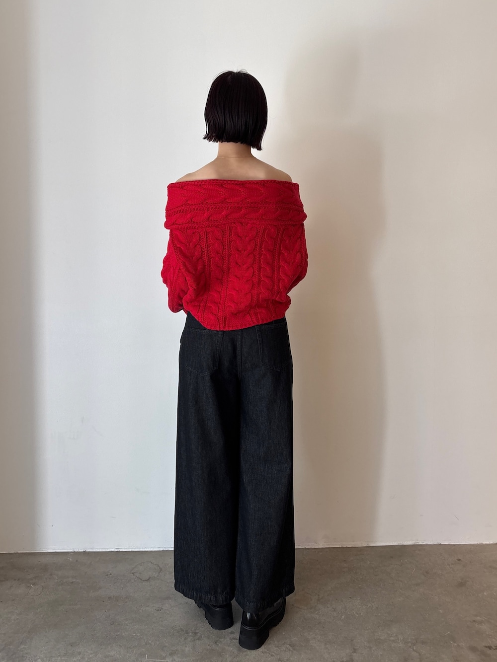 ブラック系のデニムパンツ、レッド系のニット/セーター、ブラック系のローファーを着用したレディースの秋コーディネートの5枚目の写真