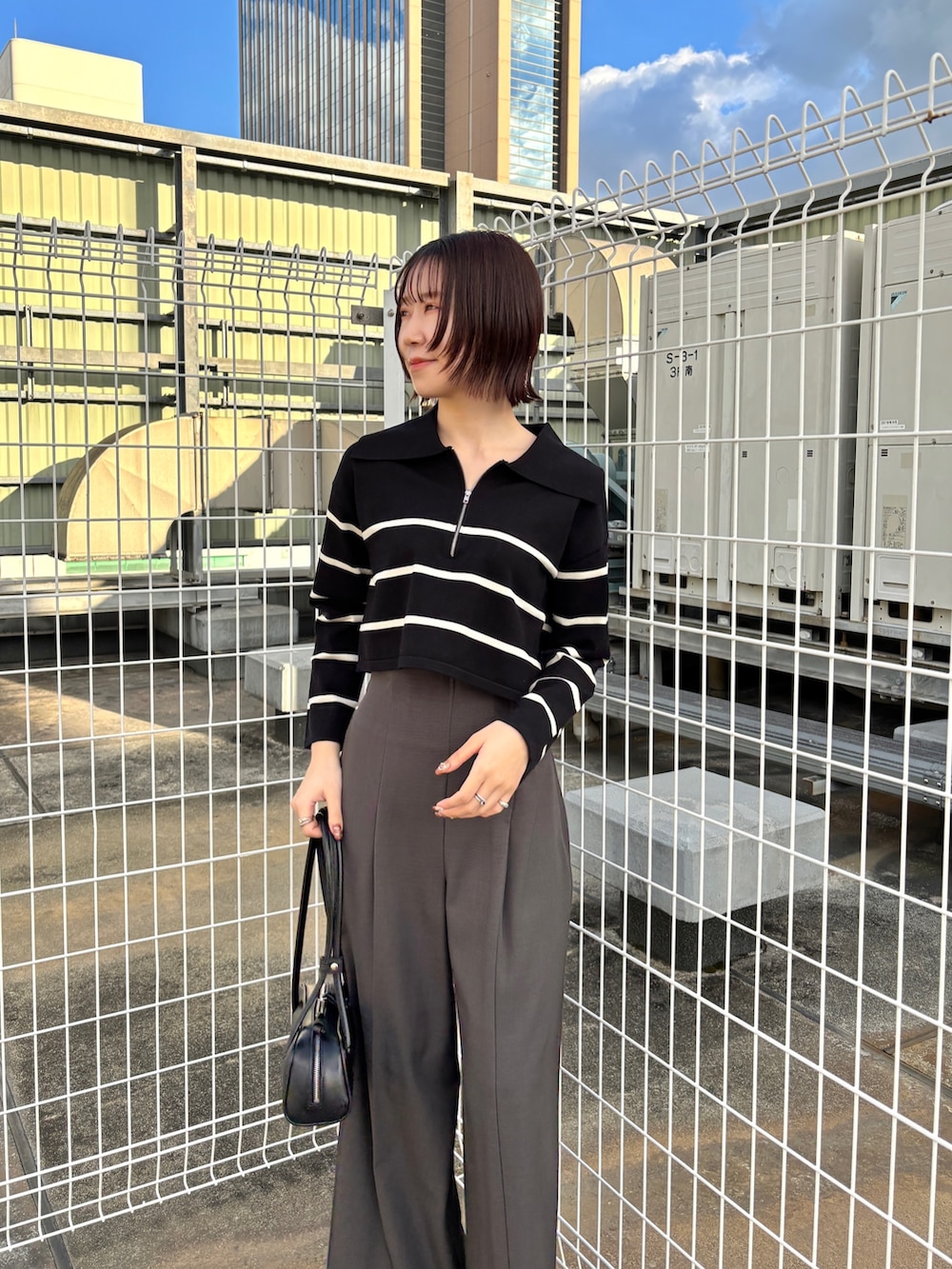 グレー系のその他パンツ、ブラック系のニット/セーター、グレー系のムートンコートを着用したレディースの冬コーディネートの4枚目の写真