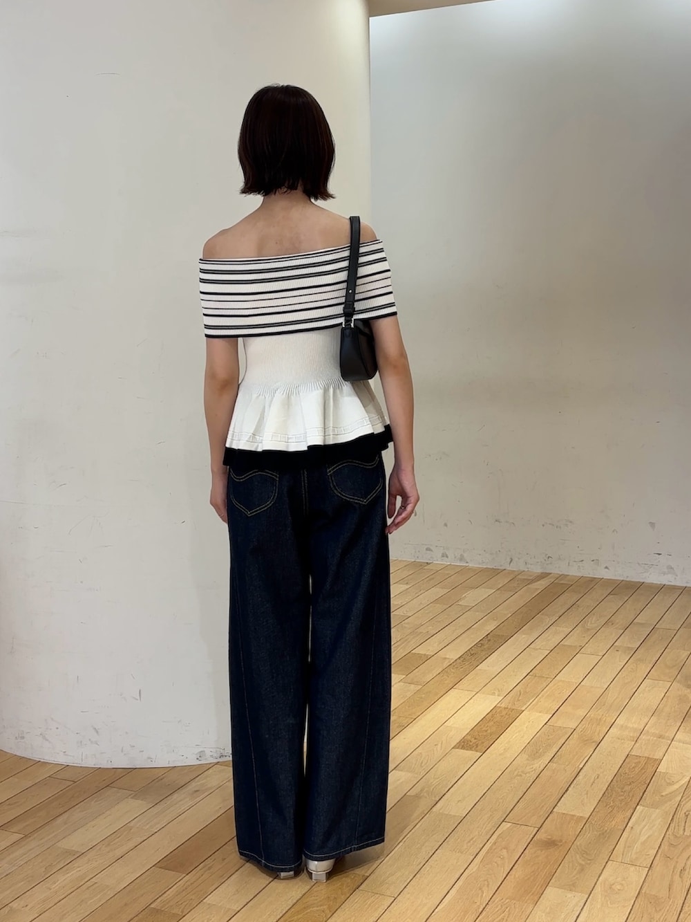 ホワイト系のニット/セーター、ブルー系のデニムパンツ、ブラック系のハンドバッグを着用したレディースの夏コーディネートの4枚目の写真