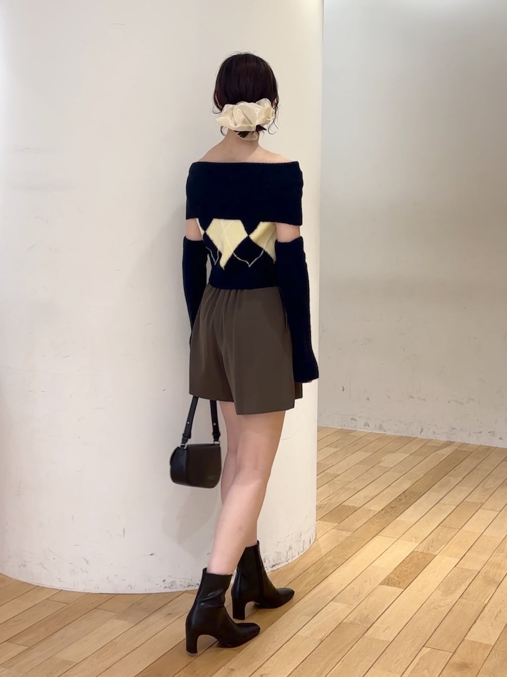 ブラウン系のその他パンツ、ブルー系のニット/セーター、ブラック系のハンドバッグを着用したレディースの夏コーディネートの3枚目の写真