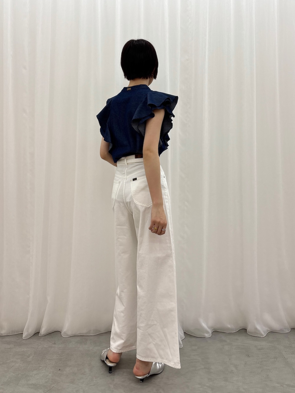 ホワイト系のデニムパンツ、ブルー系のシャツ/ブラウス、シルバー系のサンダルを着用したレディースの春コーディネートの4枚目の写真