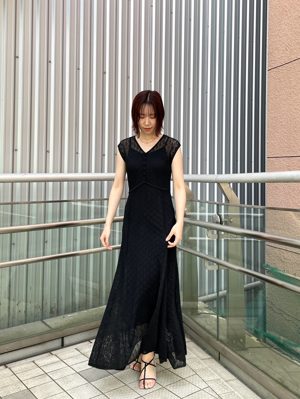 ブラック系のサンダル、ブラック系のワンピースを着用したレディースの夏コーディネートの3枚目の写真