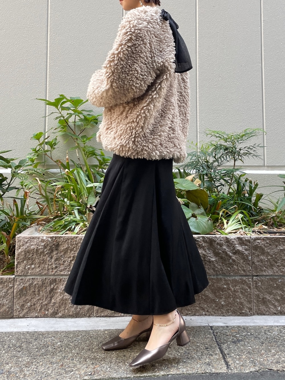 ゴールド系のハンドバッグ、その他のパンプス、ブラック系のドレスを着用したレディースの秋コーディネートの4枚目の写真