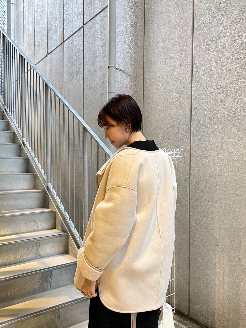 ブラック系のその他シューズ、ホワイト系のハンドバッグ、ブラック系のワンピースを着用したレディースの冬コーディネートの6枚目の写真