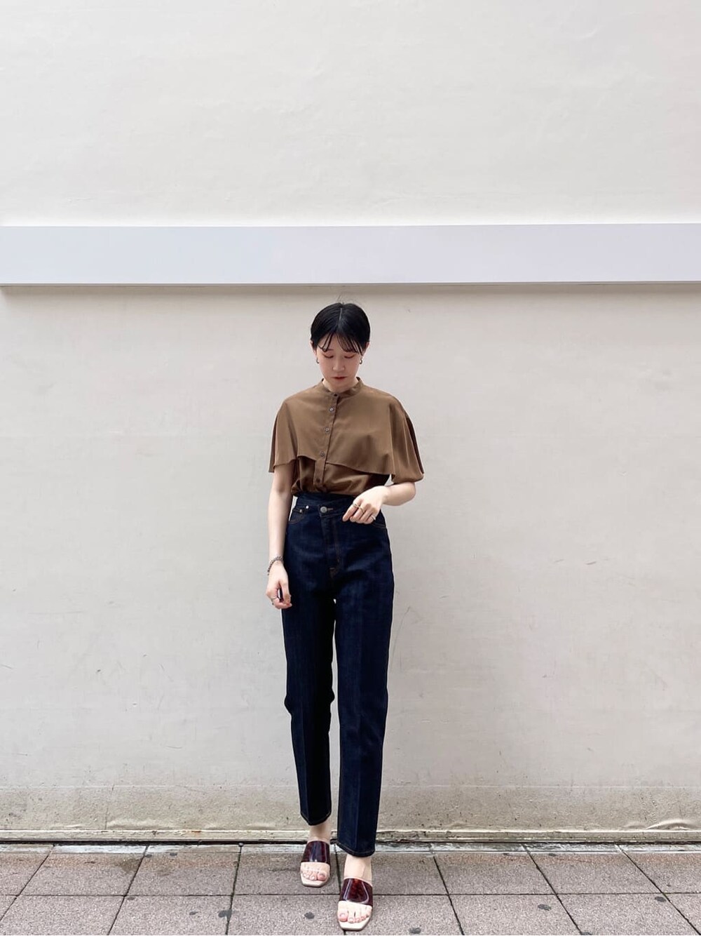 ブラウン系のサンダル、ブラウン系のシャツ/ブラウス、ブルー系のデニムパンツを着用したレディースの夏コーディネートの2枚目の写真