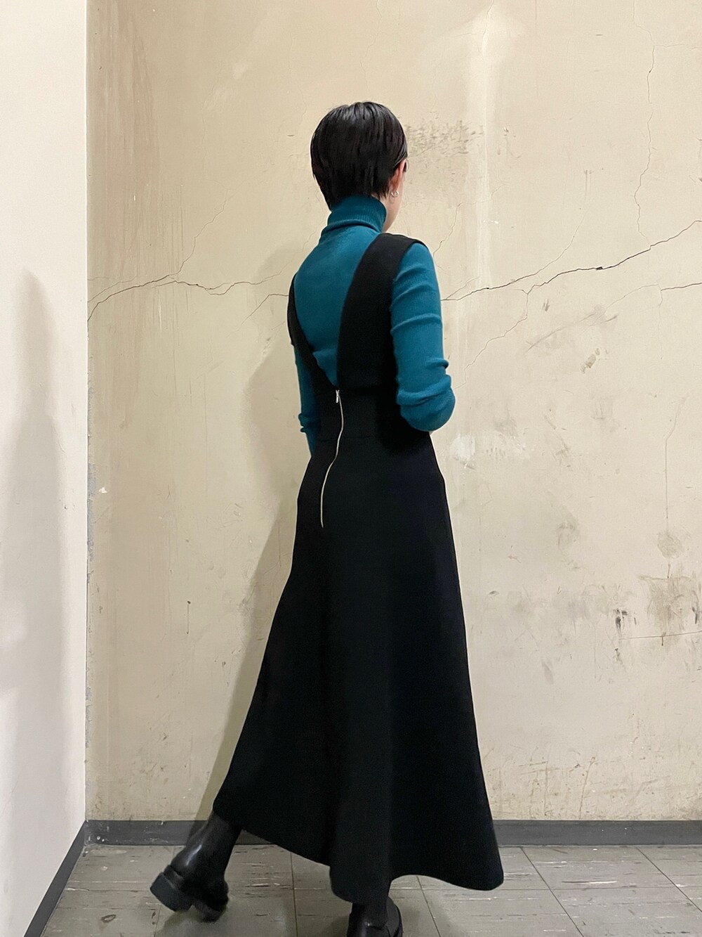 ブラック系のスカート、グリーン系のニット/セーター、ブラック系のブーツを着用したレディースの秋コーディネートの4枚目の写真