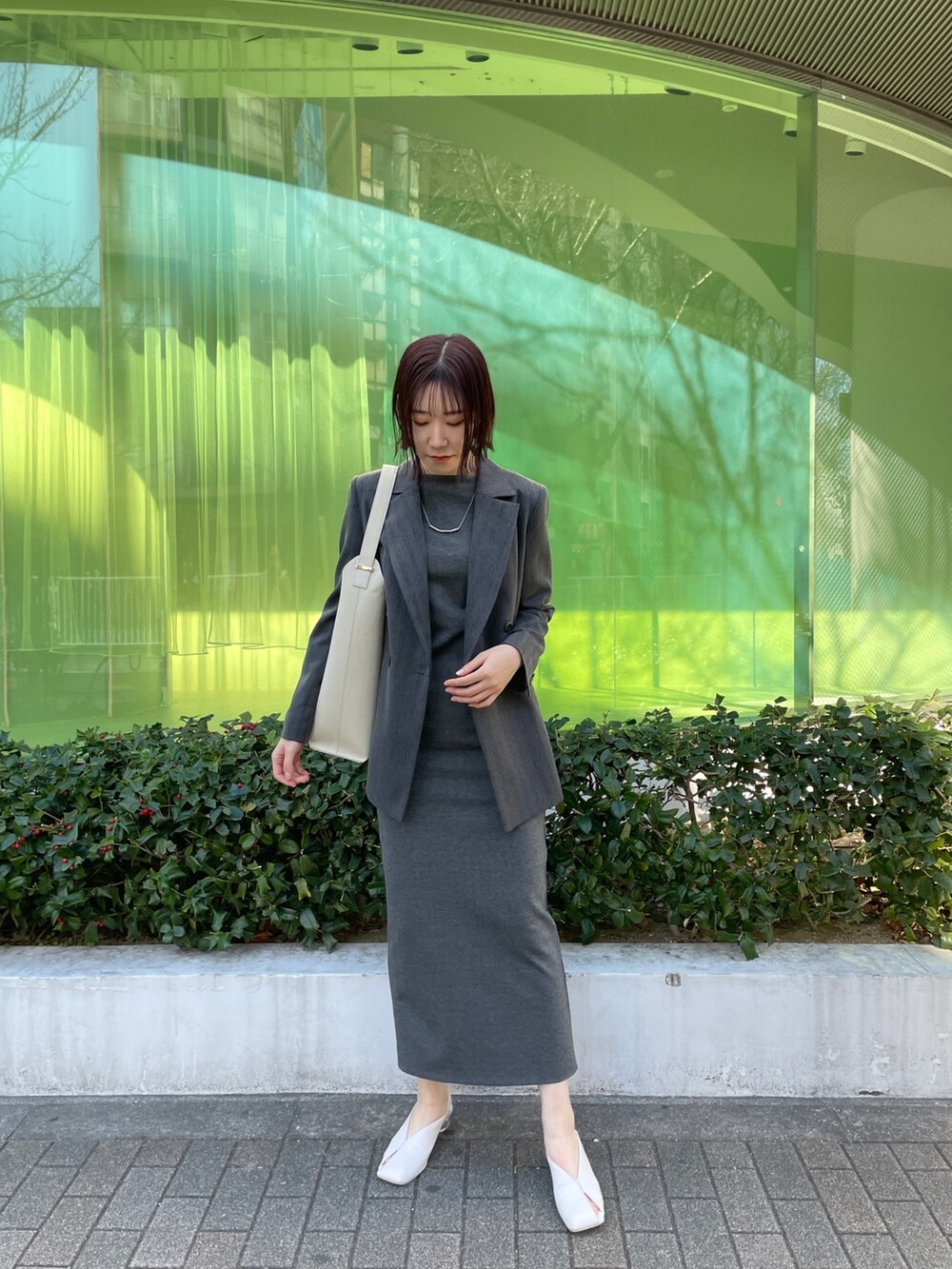 ホワイト系のパンプス、ホワイト系のショルダーバッグ、グレー系のワンピースを着用したレディースの冬コーディネートの4枚目の写真