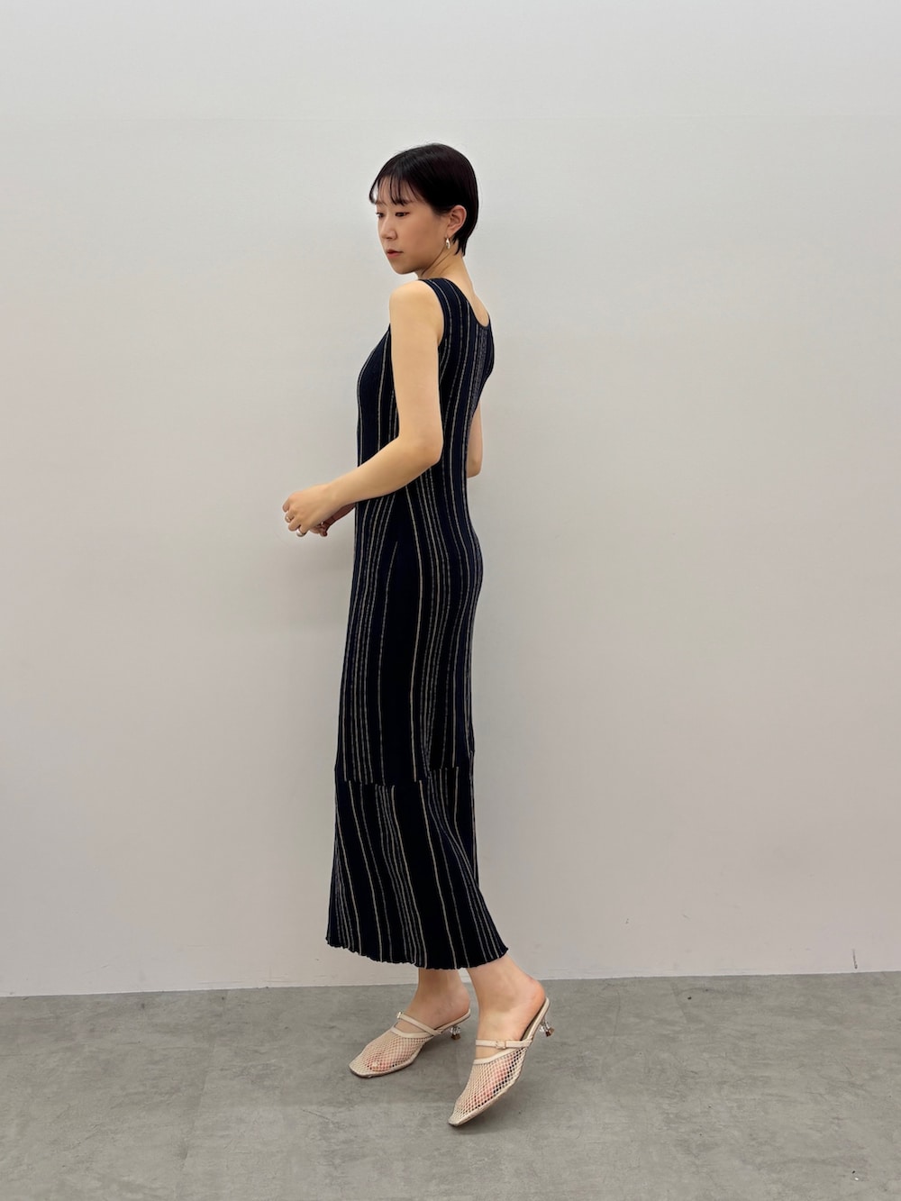 ブルー系のワンピース、ホワイト系のサンダル、シルバー系のピアス（両耳用）を着用したレディースの春コーディネートの3枚目の写真